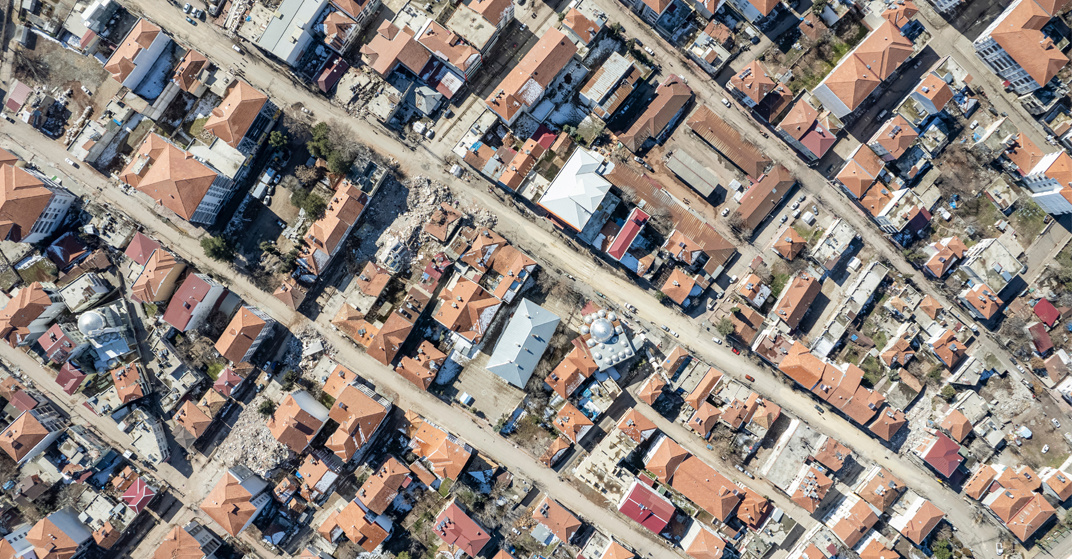 Luftaufnahme zerstörter Häuser und Straßen nach dem starken Erdbeben in der Südosttürkei 2023