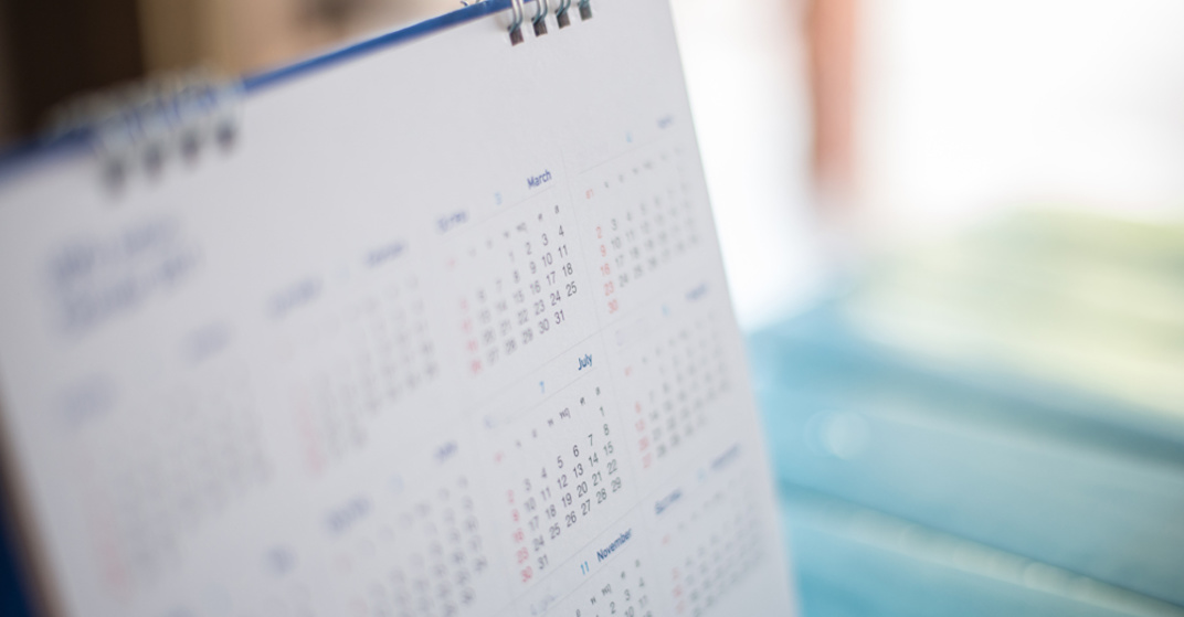 Blau-weißer Stehkalender mit Monatsüberblick eines Jahres vor hellem Hintergrund 
